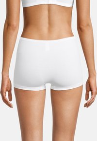 Slip di cotone bianco con una texture liscia, design hipster e cintura elastica. Le cuciture piatte e l'assenza di etichette visibili aumentano il comfort.
