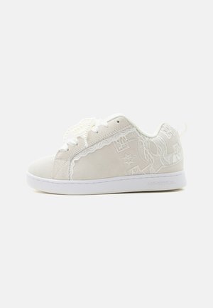 White low-top sneaker with lace detailing, embroidered patterns, white laces, and a white sole on a plain light background.