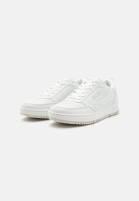 Baskets blanches en cuir lisse, à bout arrondi, avec des détails perforés, des lacets plats et un logo embossé sur le côté. Semelle en caoutchouc épaisse.