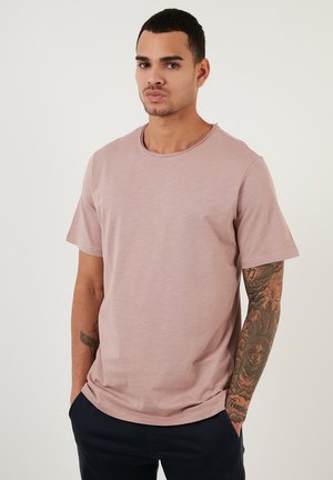 Helles rosa T-Shirt mit kurzen Ärmeln, Rundhalsausschnitt, weicher Textur, lockerer Passform, mit dezenten Nähdetails und minimalistischem Design.