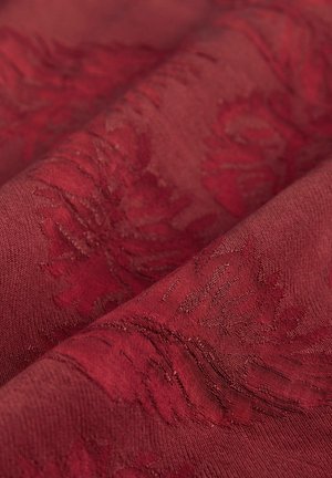 Tissu texturé en bourgogne profond, présentant un motif floral subtil. Le matériau semble légèrement lustré avec une riche texture tissée.