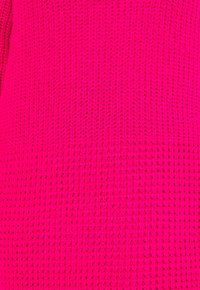 Helle rosa gestrickte Stoff mit einem strukturierten Muster, das ein offenes Gewebedesign und eine glatte Oberfläche aufweist. Keine sichtbaren Beschläge oder Akzente.
