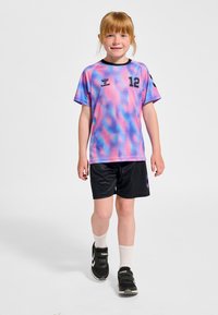 Kortärmad tröja i lila och blå gradient med nummer 12; svarta shorts med logotyp; svarta träningsskor och vita strumpor.