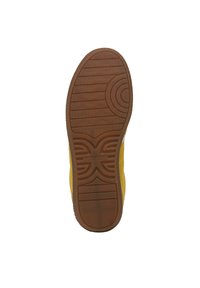 Scarpa in suede giallo con suola in gomma, caratterizzata da un fondo testurizzato e con motivo. Il design include accenti circolari e ondulati.