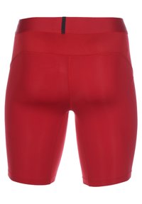 Rote Sportshorts aus glattem, dehnbarem Material. Sie verfügen über ein nahtloses Design, eine figurbetonte Form und einen schwarzen Taillenbund.