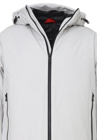 Giacca soft-shell grigio chiaro con cappuccio aderente, chiusura frontale con zip e due tasche laterali con zip. Fodera nera e dettagli in zip.