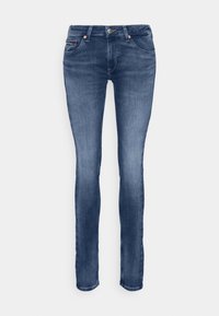 Vaqueros de mezclilla en azul oscuro con un corte ajustado, que cuentan con una bragueta de botones, cinco bolsillos y sutiles detalles metálicos cerca de los bolsillos.