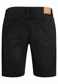 Shorts en denim noir avec une coupe droite, dotés de deux poches arrière et d'une étiquette en cuir sur la taille. Texture mate, détails de couture subtils.