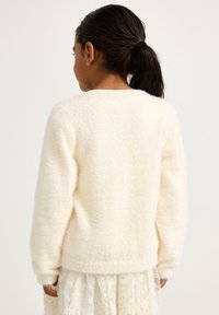 Maglione bianco e soffice con scollatura rotonda e maniche lunghe, mostrato da dietro. Il materiale sembra morbido e strutturato.