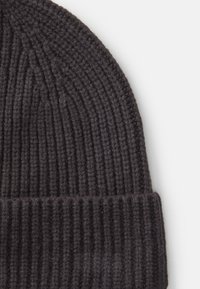 Svart stickad mössa med ribbad struktur och vikbar kant; tillverkad av mjuk ull, med jämna stygn och en sömlös design vid toppen.