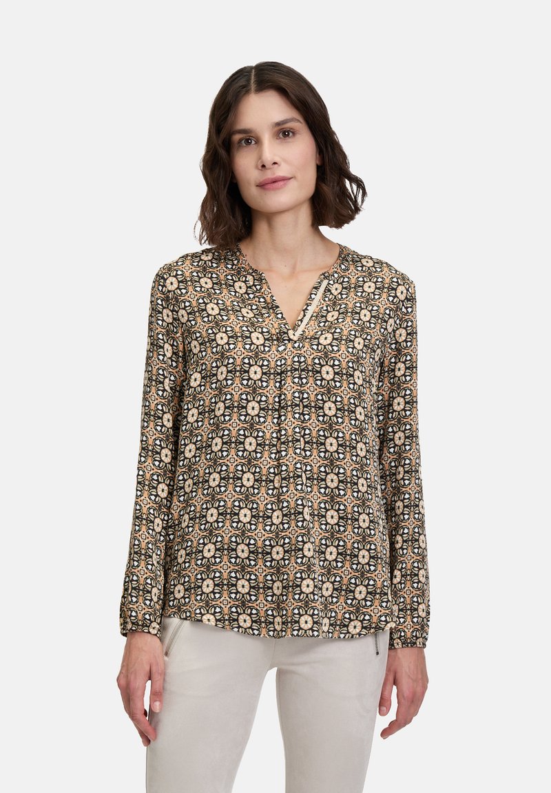 Langärmlige Bluse mit einem schwarz-beigen Blumenmuster, V-Ausschnitt und gerafften Details an den Schultern. Weiche Stofftextur.