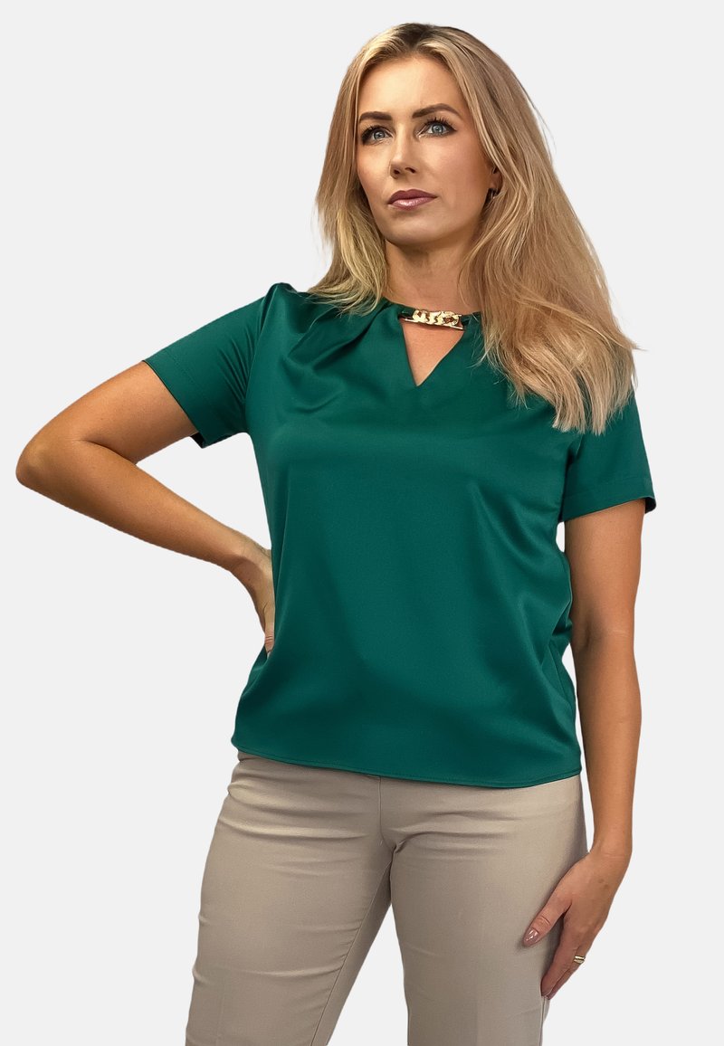 Zielona bluzka z krótkim rękawem i dekoltem w serek, ozdobiona złotymi elementami przy dekolcie, wykonana z gładkiego, lekkiego materiału.