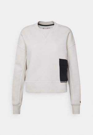 Sweatshirt beige clair à col rond, à manches longues, avec une poche latérale noire. Finitions avec des poignets et un ourlet côtelés.