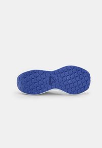 Semelle de chaussure de sport blanche avec une semelle extérieure en caoutchouc bleue texturée comprenant un motif triangulaire et un détail de logo.