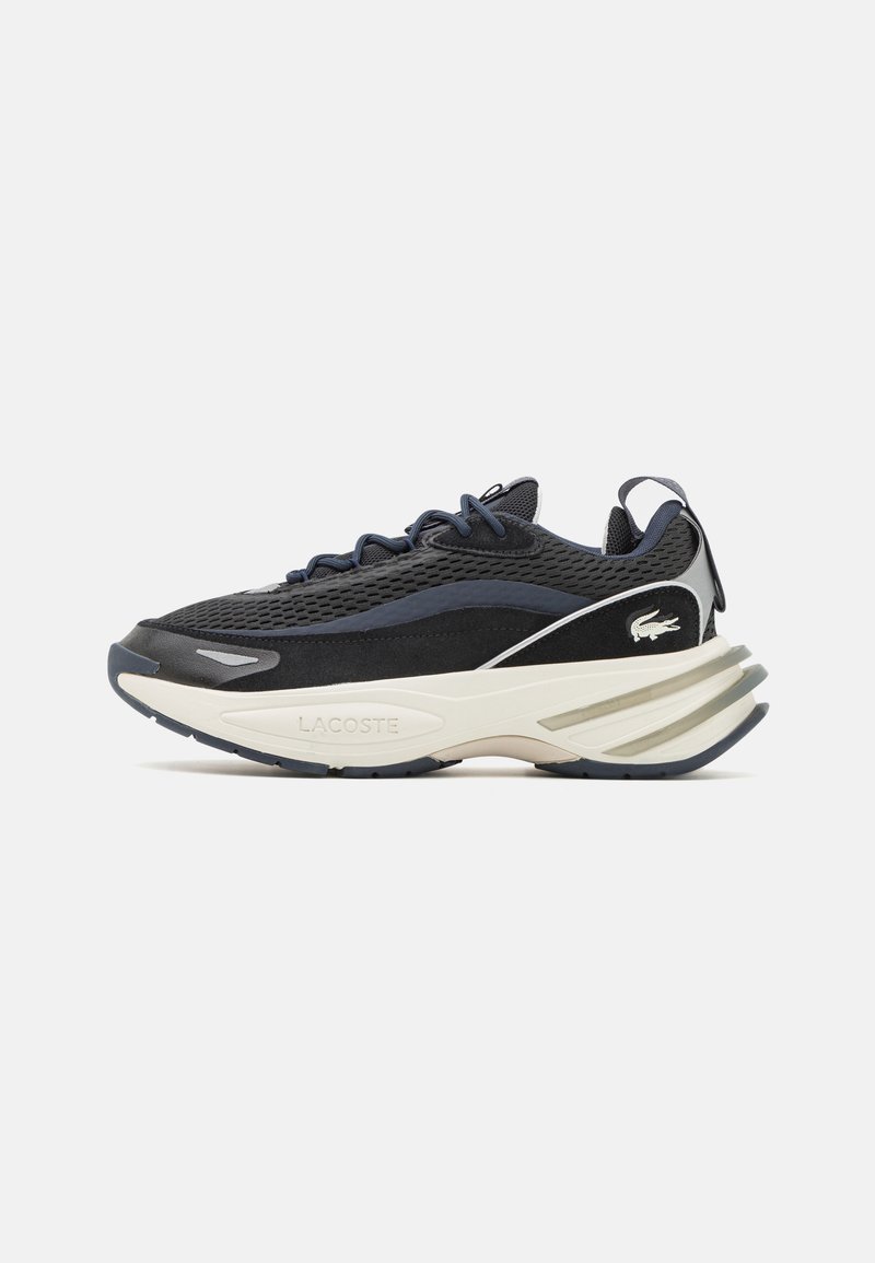 Basket en mesh noir et suède avec une semelle intermédiaire blanche, des accents navy et un logo Lacoste proéminent sur le côté et à l'arrière. Présente une languette rembourrée.