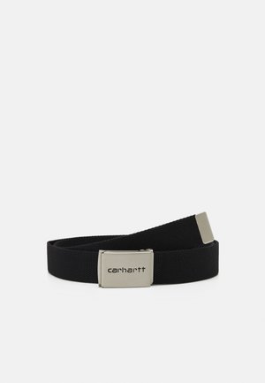 Zwarte geweven stoffen riem met zilverkleurige rechthoekige gesp gegraveerd met het "carhartt" logo, opgerold gelegd op een witte achtergrond.