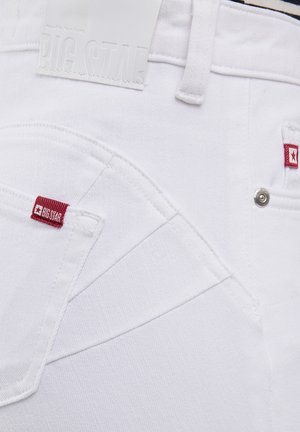 Białe dżinsy wykonane z denimu z fakturowaną powierzchnią, czerwonymi akcentami z logo oraz charakterystycznym wykończeniem kieszeni. Zawierają białą, wytłoczoną metkę z logo marki.