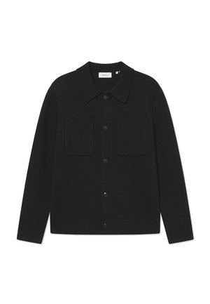 Veste noire à manches longues avec boutons, col et deux poches poitrine avant, présentée sur fond blanc.