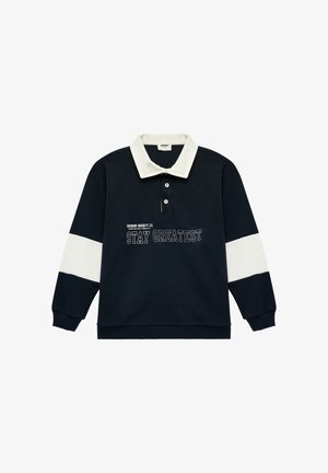 Marineblauw poloshirt met lange mouwen, witte kraag en strepen op de mouwen, met de tekst "STAY GREATEST" op de voorkant.