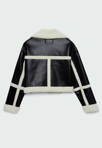 Chaqueta de cuero negro recortada con acentos de piel de oveja blanca. Presenta un cuello ancho y un diseño de panel geométrico en la parte posterior y las mangas.