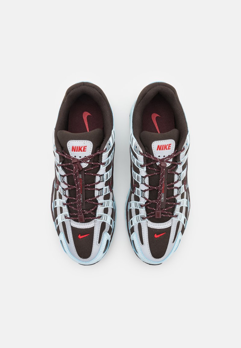 Baskets Nike avec une tige en mesh et synthétique, arborant une palette de couleurs marron et bleu clair, avec des accents rouges et un design à lacets.