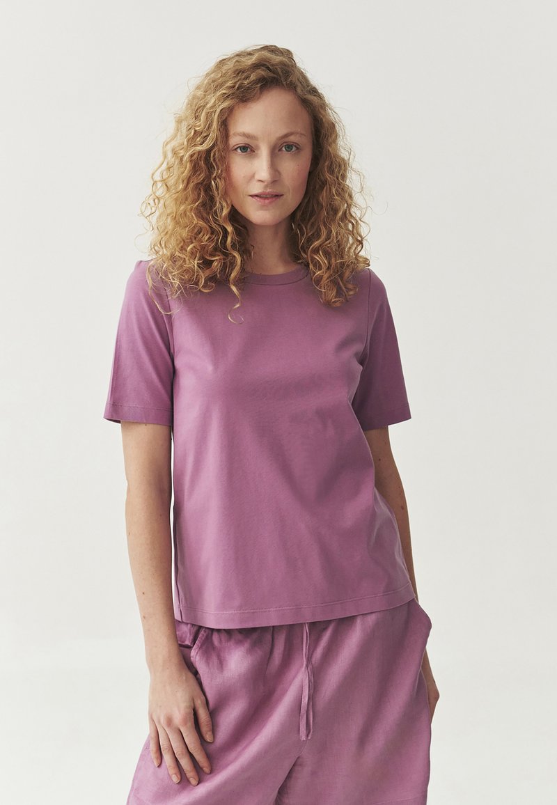 Purple cotton T-shirt with short sleeves and a crew neckline, paired with matching shorts. Smooth texture with minimal detailing.