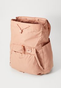 Roze nylon rugzak met een trekkoordsluiting, voorvak en zijknopen. Heeft een gladde textuur en minimale merkdetails.