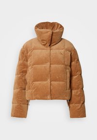 Doudoune en velours côtelé beige avec col montant, boutons-pression, poches latérales et motif matelassé, présentée sur un fond blanc uni.