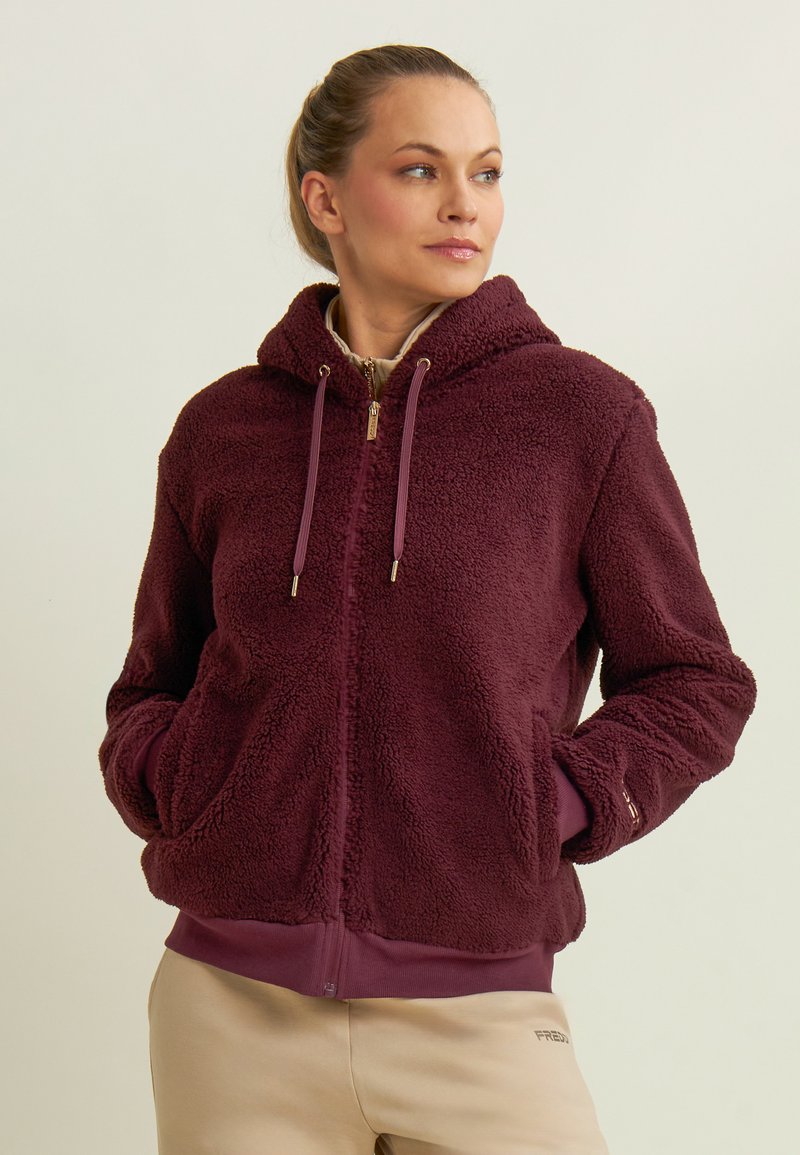 Felpa borgogna con zip, realizzata in morbido fleece, dotata di cappuccio regolabile con coulisse, tasche frontali e polsini a costine, con una fodera interna liscia.