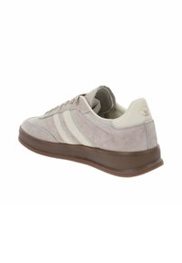 Sneaker in suede grigio con accenti di striscia bianca, punta arrotondata, chiusura con lacci frontale e suola in gomma marrone. Presenta un collare imbottito per il comfort.