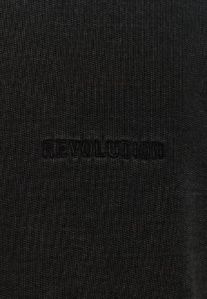 Schwarzer Strickstoff mit strukturierter Oberfläche, in dessen Mitte das Wort "REVOLUTION" in einem dunkleren Farbton eingeprägt ist.