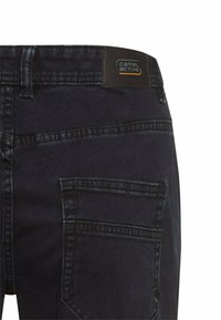 Donkerdenimbroek met een rechte snit, voorzien van een achterzak, gestikte details en een merkpatch op de tailleband.