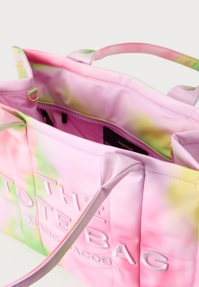 Sac fourre-tout tie-dye rose et vert avec longues anses et ouverture zippée visible, avec texte blanc en relief à l’extérieur.