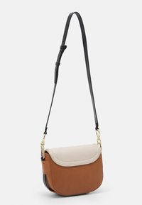 Borsa a tracolla in pelle marrone e crema con forma curva, chiusura a pattina, accessori in oro e tracolla nera regolabile.
