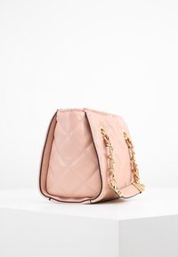 Quilted pink leather handbag with gold chain accents and a structured rectangular shape; features textured surface and contrasting edges.