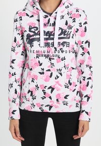 Felpa con Cappuccio grigia chiara con motivo floreale rosa, dotata di una tasca frontale e testo grafico nero. Tessuto morbido con polsini a coste.