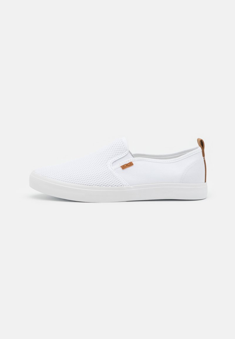 White slip-on shoes made of mesh and canvas, featuring a flat rubber sole and a small brown accent tag on the side.