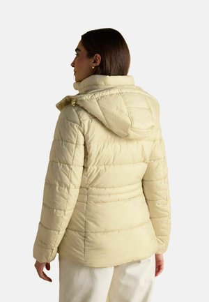 Light beige puffer jacket with horizontal stitching, a hood, and a zipper closure. Features include side pockets and a soft, textured finish.