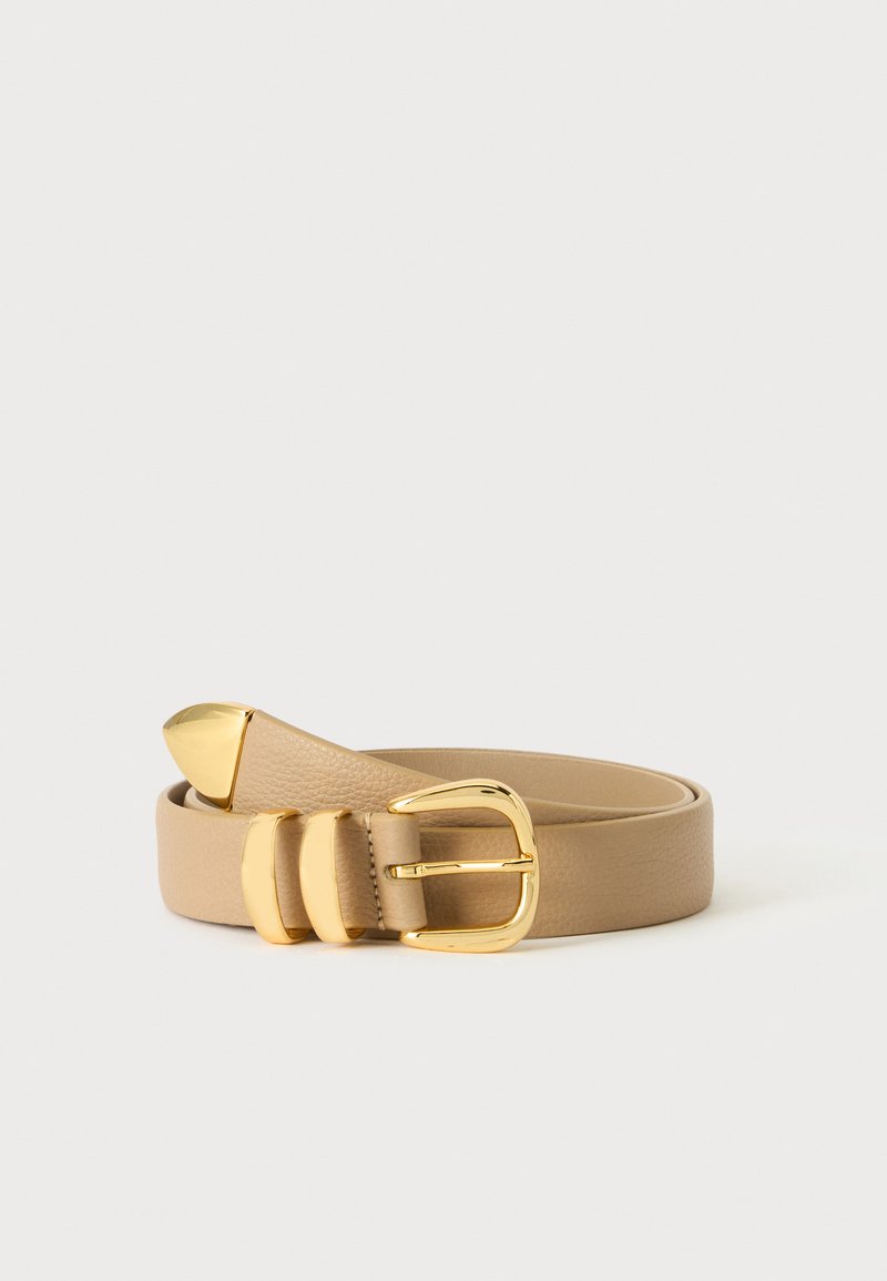 Ceinture en cuir beige roulée avec une boucle dorée, deux passants dorés et une extrémité dorée sur un fond clair.