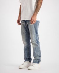 Lichtblauwe denim jeans met een relaxed fit, voorzien van versleten details en vervaging. G gedragen met witte schoenen en een eenvoudig wit T-shirt.