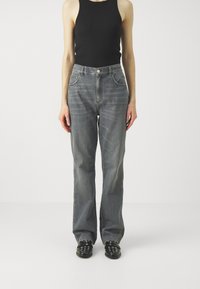 Gray denim jeans with a high waist, straight leg, and two front pockets, paired with a black tank top and black studded shoes.