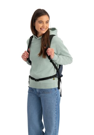 Hooded sweatshirt in light green, paired with blue jeans and a black backpack. Features adjustable straps and a front buckle.