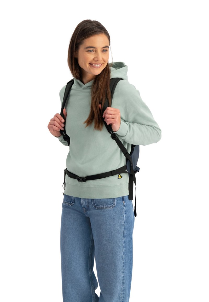 Een lichtgroene capuchontrui, gecombineerd met blauwe jeans en een zwarte rugzak. Het heeft verstelbare banden en een voorbuckle.