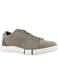 Graue Wildledersneaker mit flachen Schnürsenkeln, weißer Gummisohle und einem kontrastierenden braunen Akzent an der Ferse. Glatte Oberfläche. 