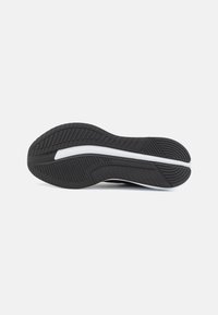 Black rubber shoe sole with textured grooves and a white midsole stripe, featuring a rounded heel and a flat front for traction.