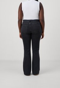 Jeans neri a zampa d'elefante con vita alta, realizzati in denim. Presentano due tasche posteriori e un leggero stretch per il comfort.