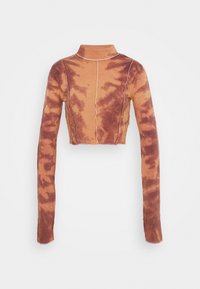 Långärmad, kort turtleneck-top med brun och beige tie-dye-mönster samt synlig vit sömnad på en enfärgad bakgrund.
