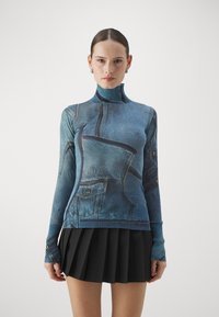 Ilga rankovė turtleneko palaidinė, papuošta džinsų raštu, su gofruotais rankogaliais ir prigludusia forma. Su "Versace Jeans Couture" ženklu.