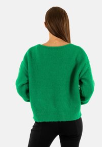 Maglione verde in maglia con una vestibilità ampia, maniche larghe, polsini e orlo a costine, caratterizzato da una finitura texturizzata e un collo a giro.