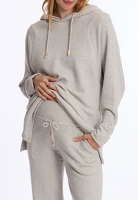 Lichtgrijze hoodie met een trekkoordkap, lange mouwen en een losse pasvorm, gecombineerd met bijpassende joggers met een elastische tailleband.